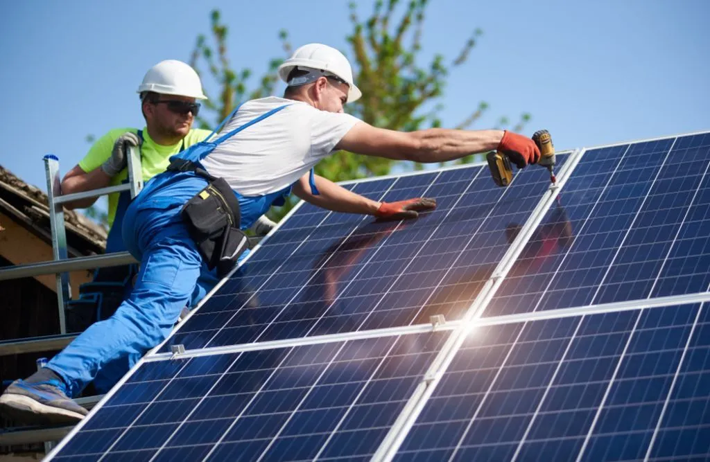 The Vital Role of Solar Panel Recycling in the Circular Economy 3 Couple of solar engineers installing solar cells on the roof